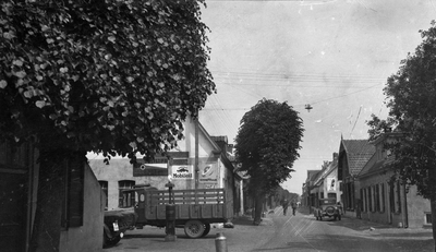 852038 Gezicht in de Voorstraat te Woudenberg, uit het westen, met links de benzinepomp van garage Honders.